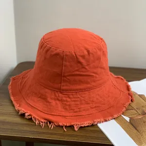 Detailaufnahme des orangefarbenen Anglerhuts aus Canvas mit Fransen und Ziernähten