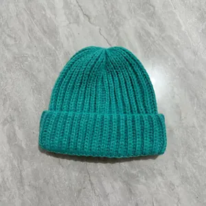 Detail shot of the thick ribbed knit texture and lake green fabric of this winter beanie