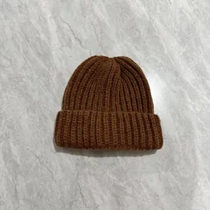 Detailed view of the dark brown ribbed knit pattern and soft texture on a winter beanie