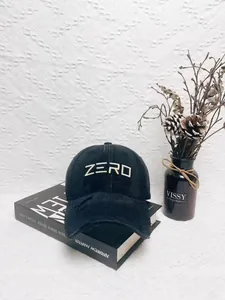 Close-up of distressed baseball cap featuring bold ZERO embroidery and frayed brim details