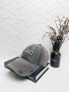 Detailed close-up of vintage distressed baseball cap with Zero embroidery and torn edges