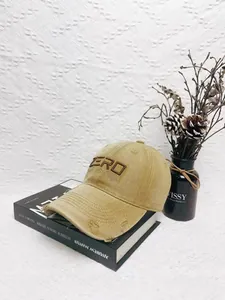 Close-up of khaki distressed baseball cap with Zero embroidery on vintage books