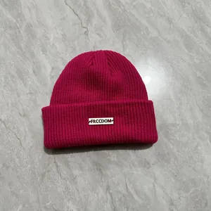 Dettaglio del berretto fucsia a maglia a coste con etichetta rettangolare logo FRCCDOM