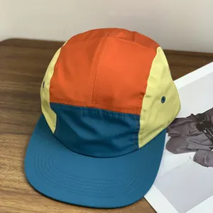 Waterproof 5-panel retro sports cap with multicolor panels on a wooden surface