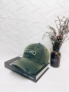 Detailed close-up of olive green distressed baseball cap with white ZERO embroidery