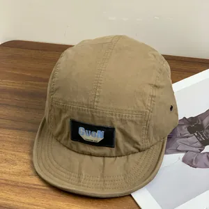 Detail of khaki five-panel cap with GuoN logo patch on rustic wooden background
