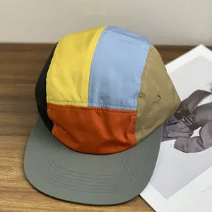 Detailed top view of a multi-color five-panel camper hat in waterproof fabric