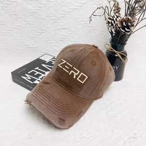 Vintage brown distressed baseball cap with zero embroidery and worn detail on white background