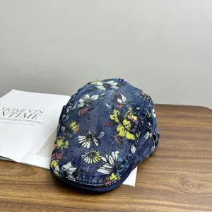 Detailed close-up of floral print vintage washed denim baseball cap on a wooden table