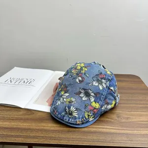 Detail of floral printed denim baseball cap with metal buckle on rustic wooden table