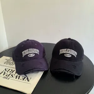 Casquette baseball vintage avec broderie de lettres et détails de bord déchirés