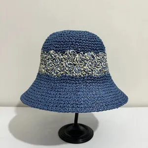 Close-up of hand-woven texture on a navy blue bucket hat with cream hollow floral pattern