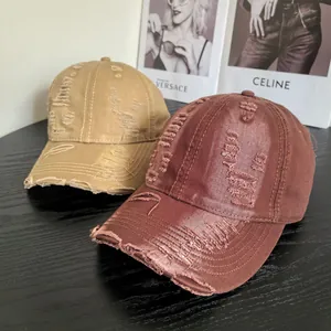 Distressed cotton baseball caps with vintage ripped holes and frayed edges in earth tones