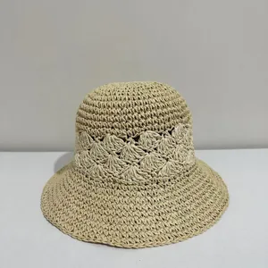 Close-up of hand-woven straw bucket hat with intricate hollowed-out floral knit details