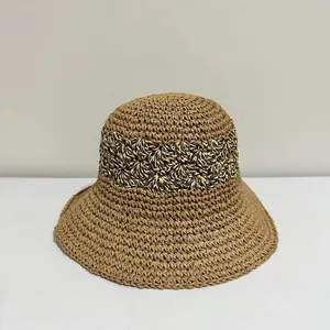 Macro detail of the breathable straw weave texture and brown bucket hat embroidery pattern