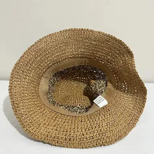Detail view of the breathable straw bucket hat featuring inner sweatband and material label
