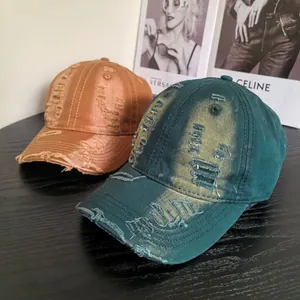 Close-up of distressed cotton baseball caps with washed finish and ripped details