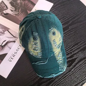 Distressed dark green baseball cap with ripped details and retro sun-faded finish