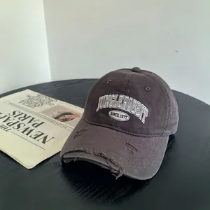 Gros plan d'une casquette de baseball gris foncé avec broderie blanche vintage