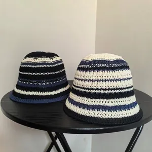 Close-up of crochet texture on navy and beige striped knit bucket hats for summer