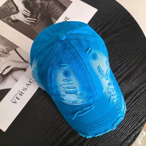 Top view of bright blue distressed cotton canvas baseball cap with ripped details