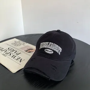 Broderie détaillée de lettres blanches sur une casquette en coton noir style usé