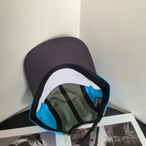 Detail view of a five-panel camping hat featuring multi-color patchwork and cotton texture
