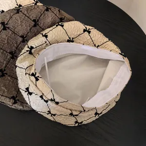 Detail of seersucker beret featuring quilted bow patterns and elastic inner band