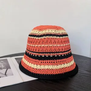 Detailed close-up of handmade crochet bucket hat with vibrant contrast stripes and black brim
