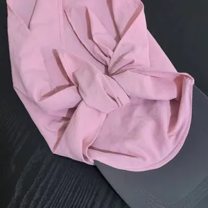 Close-up of pink quick-dry fabric with knot detail and gray sun visor stitching