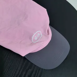 Detail of pink and gray quick-dry camping hat showing the Nice embroidery and stitching