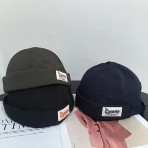 Three-color docker hats in dark green, black and navy with camping label embroidery
