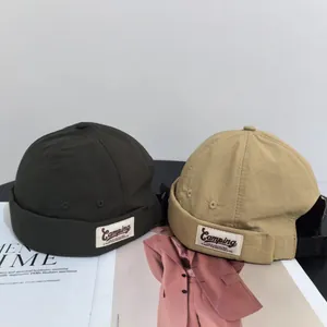 Deep green and khaki docker hats with camping patch on stylish magazine background
