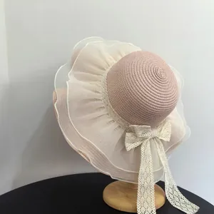 Elegant pink straw sun hat with white organza wavy brim and lace bow for summer beach travel