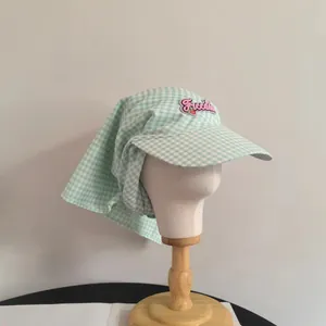 Dettaglio cappello parasole a quadretti verde chiaro con ricamo Freedom e protezione nuca