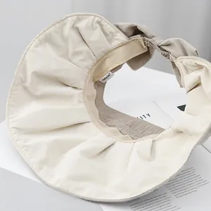 Detail view of beige sun hat with textured fabric and elegant rear bow design