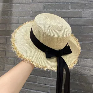 Cappello di paglia a cima piatta con fiocco nero e bordi sfrangiati per vacanze estive