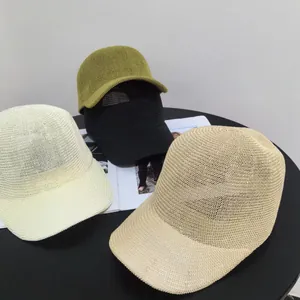 Detail view of woven straw baseball caps in beige, khaki, black and green summer colors