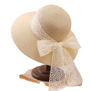 Beige woven straw sun hat for women featuring a wide brim and elegant lace bow decoration