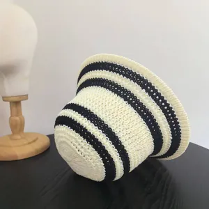 Dettaglio del cappello di paglia estivo a maglia traforata con strisce beige e nere