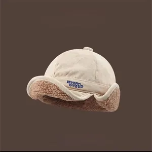 Detail view of corduroy earflap hat with lamb wool lining and Never Give Up embroidery