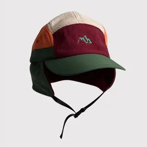 Detail view of contrast color fleece earflap hat with mountain embroidery and buckle strap