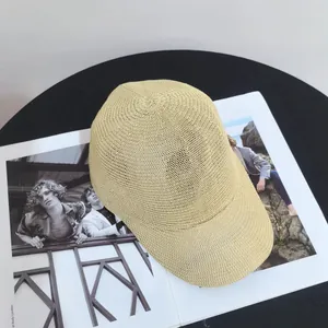 Detailed top view of breathable beige woven texture straw baseball cap on magazine