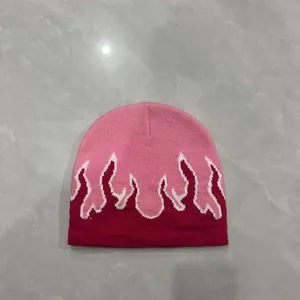 Dettaglio del motivo a fiamma jacquard su un berretto in maglia rosa e rosso