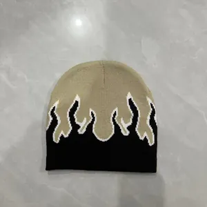 Dettaglio del berretto in maglia con motivo a fiamme su tessuto jacquard kaki e nero