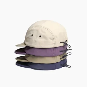 Detailed stack of breathable nylon camp caps in beige, purple, khaki, and navy blue tones