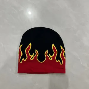 Dettaglio del berretto in maglia con motivo a fiamme e bordi gialli su nero e rosso
