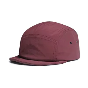 Detailed macro view of wine red camper hat with ripstop texture and metal eyelets