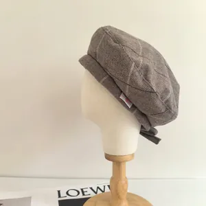 Casquette gavroche grise à motif chevrons présentée sur une tête de mannequin classique