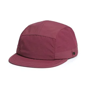 Detail of burgundy five-panel camp cap featuring breathable mesh and side metal button